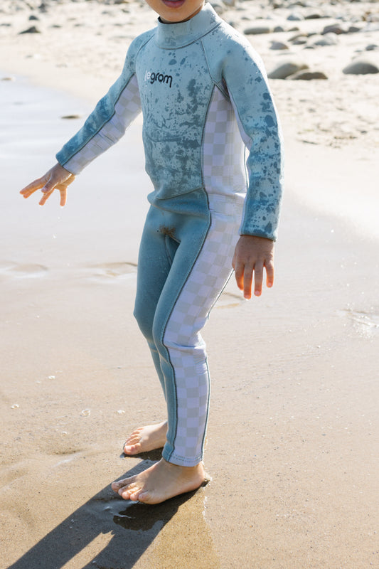 Two toddlers wearing Le Grom wetsuits running into the ocean at the beach - kids surf lifestyle